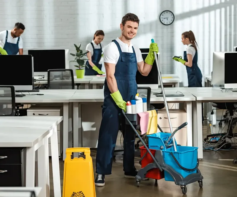 Reinigungsteam bei der Büroreinigung in Göttingen mit professioneller Ausrüstung zwischen Schreibtischen und Monitoren