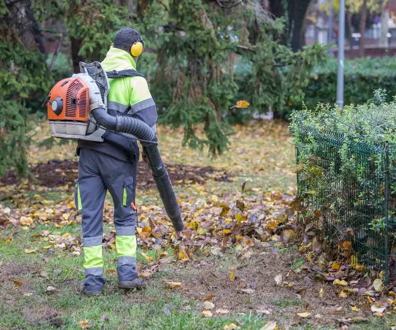 GDG Mitarbeiter bei der Gartenpflege entfernt Herbstlaub mit Laubbläser in Göttingen