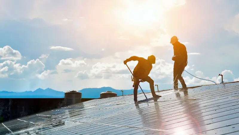 Gebäudereiniger reinigen Solaranlage unter freiem Himmel